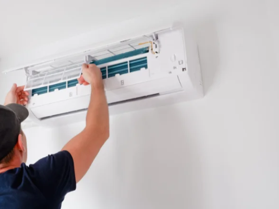 Technician working on an air conditioning system indoors