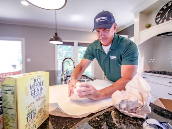 Man wrapping items on kitchen counter