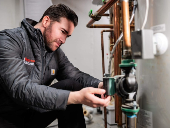 Man in jacket working on pipes in a building