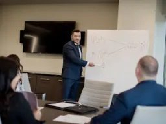 Business meeting with man presenting on whiteboard