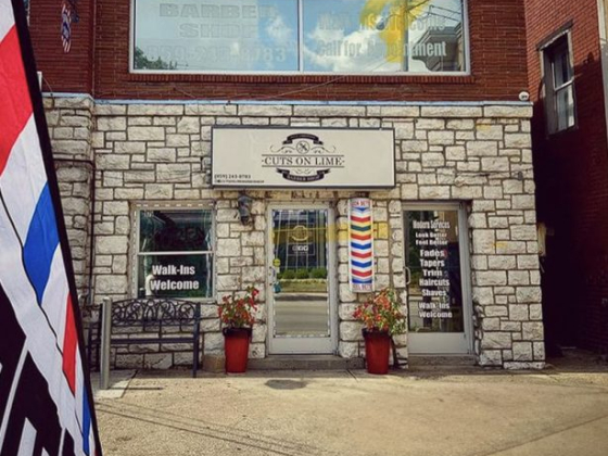 Barbershop entrance with welcome sign and red, white, blue pole