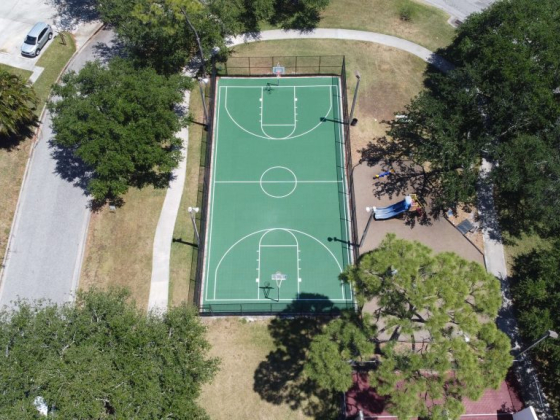 Green basketball court in a park setting from above