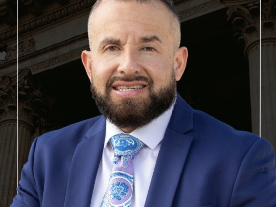 Man in formal wear standing outdoors with columns