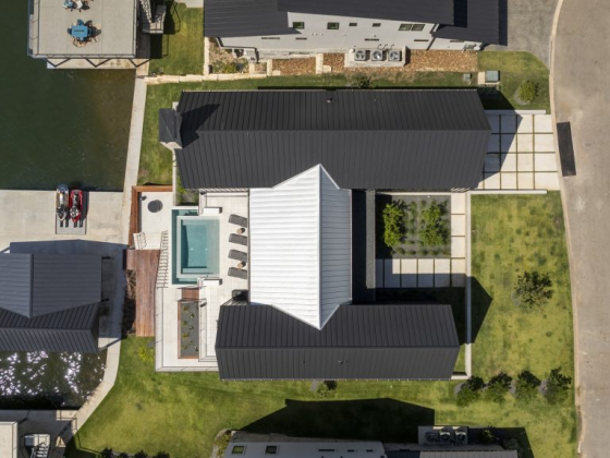 Modern home with a pool, seen from above, near a body of water