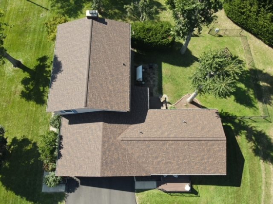Two connected roofs surrounded by green yard