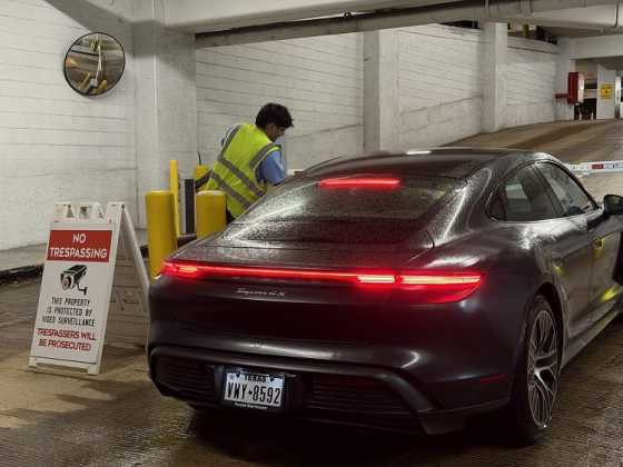 Vehicle waits at parking entrance as attendant checks security