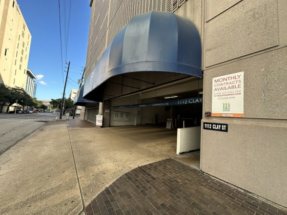 Blue awning and monthly contracts sign at garage entrance