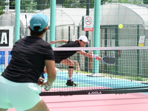 Players compete on a colorful pickleball court