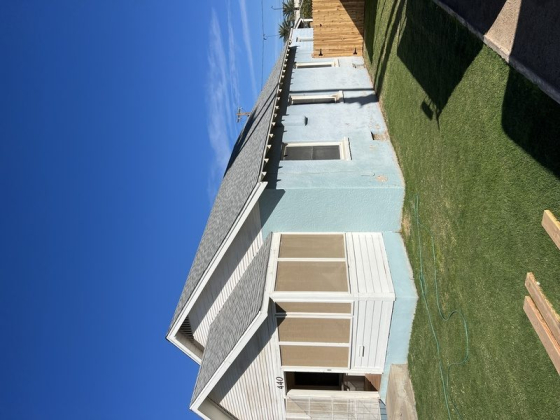 A light blue house with a well-kept lawn