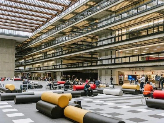 People relax in a large atrium with unique furniture.