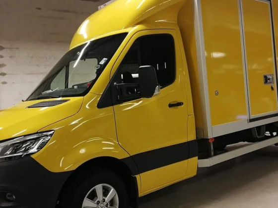 A bright yellow delivery truck inside a garage