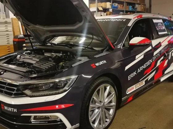 Modified race car in garage with vibrant decals