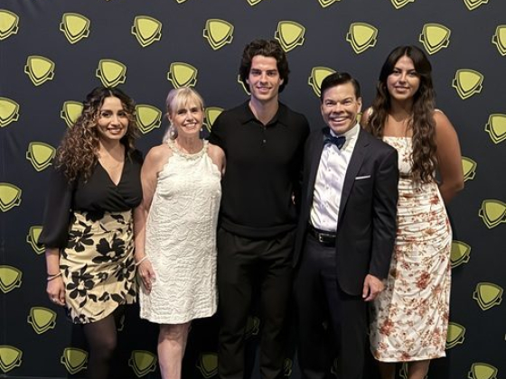 Group photo at an event with logo backdrop