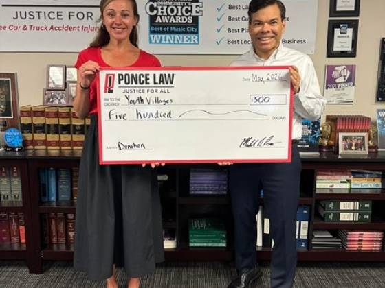 Ponce Law presents a donation check to Youth Villages