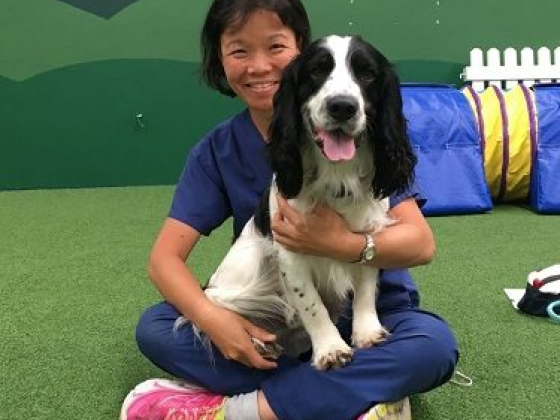Smiling woman with a dog in a play area