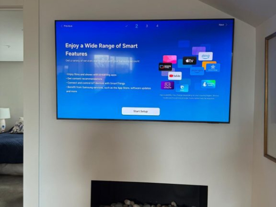 Smart TV displaying setup options mounted above a fireplace
