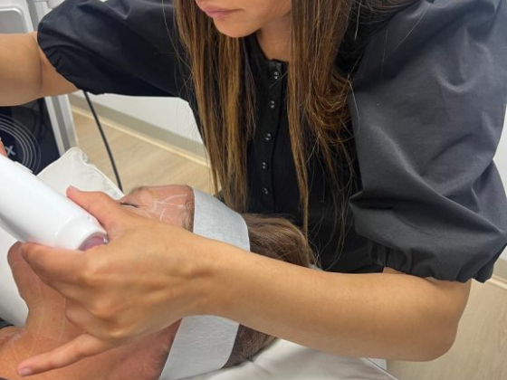 Aesthetician uses device for skin treatment