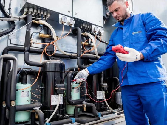 Worker tests industrial refrigeration system for maintenance
