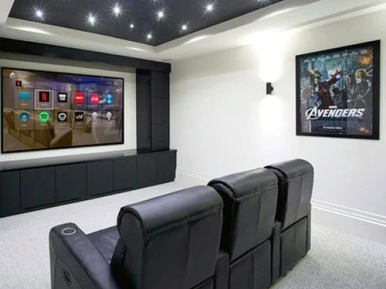 Modern media room featuring a big screen and cozy recliners