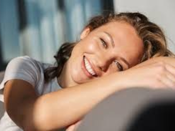 A joyful woman relaxing and smiling at home