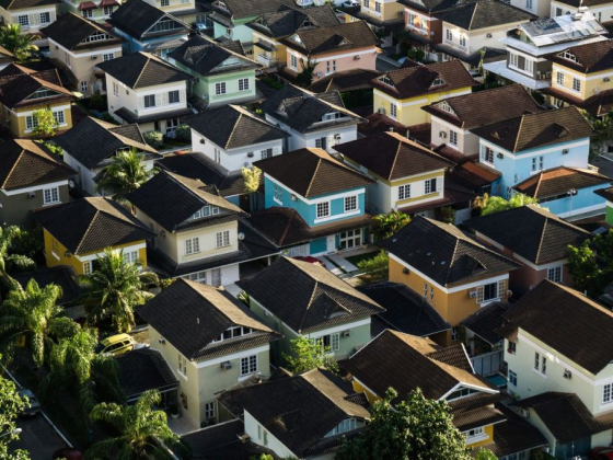 Dense neighborhood with colorful houses and lush trees