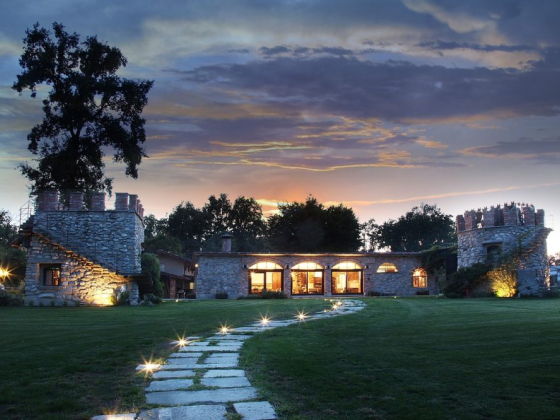 A stone building illuminated at sunset with a garden path.