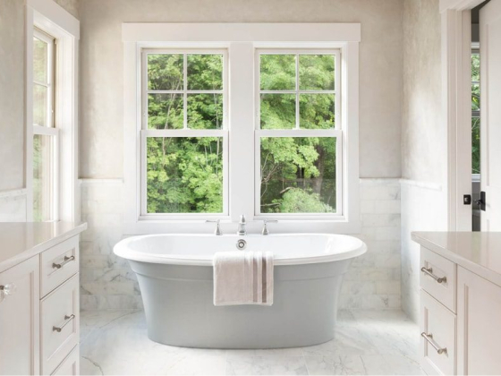 Elegant bathroom featuring a central bathtub and scenic window view