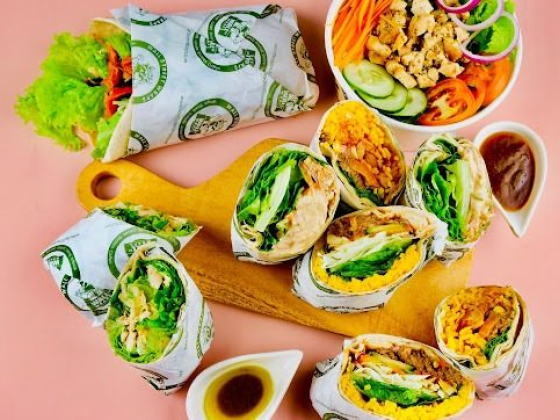 Delicious wraps and veggie salad on a wooden board