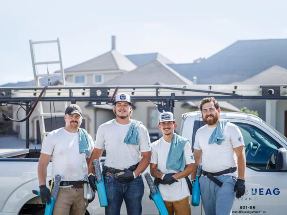 Four window cleaners posing in front of their truck with supplies