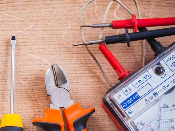 Screwdriver, pliers, and multimeter on table