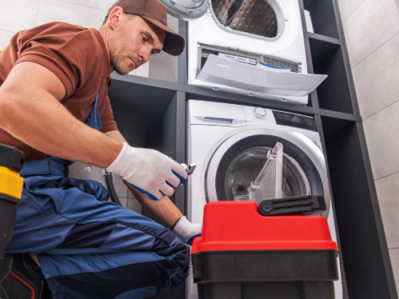A service technician working on a washing machine