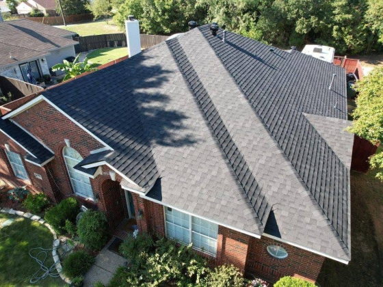 Modern house with new roof shingles and green yard