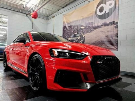 Glossy red sports car displayed indoors