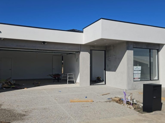 New white house with open garage in sunny setting