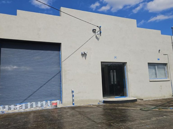 Building with blue roller door and glass entry