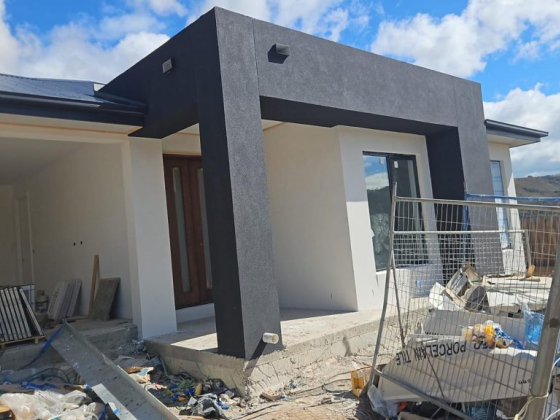 A contemporary house in progress amidst construction materials