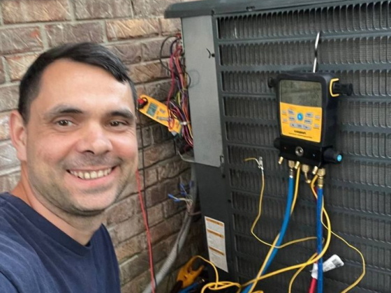 Technician performing maintenance on air conditioning unit