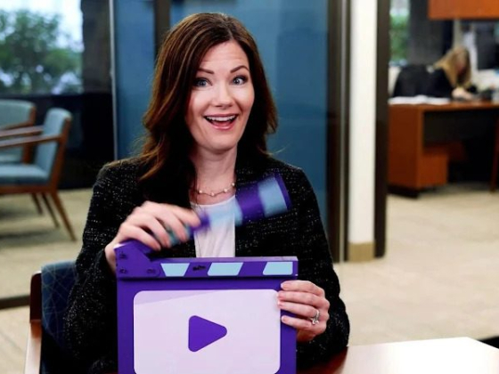 Woman with clapperboard ready for video action