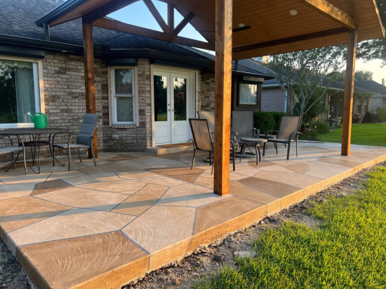 A shaded patio area with chairs and tables on stone tiles