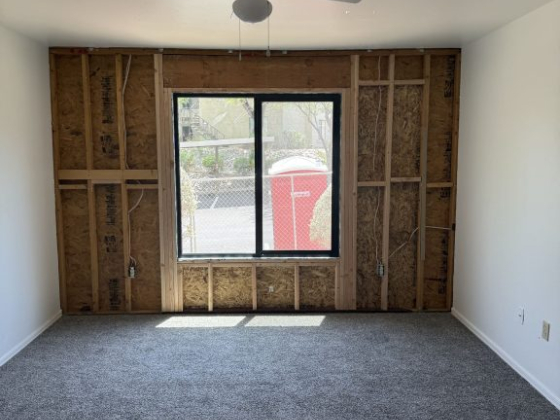 Room with unfinished wall and a large window