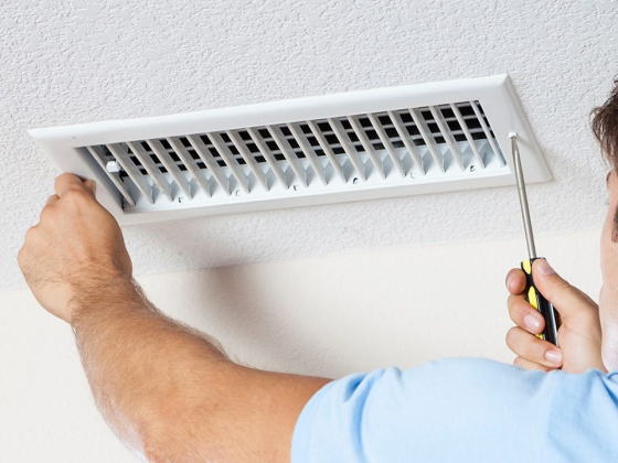 Installing an air vent on the ceiling with a screwdriver