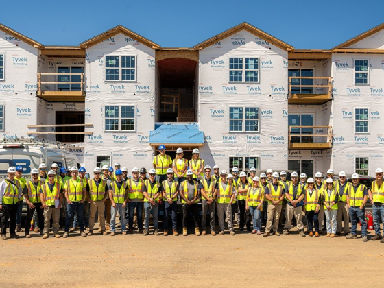 Group of workers pose at construction site