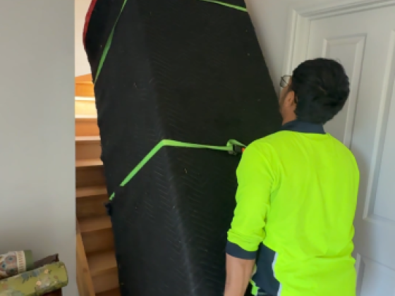Person lifting padded object on staircase indoors