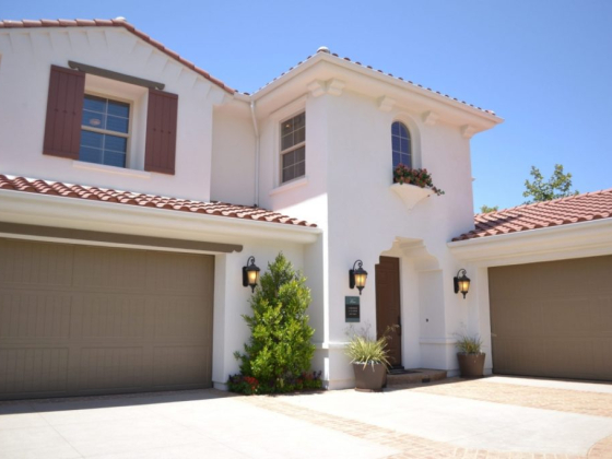 Two-story home with red-tiled roof and shutters