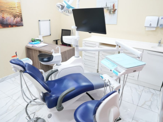 A well-equipped dental office with a blue dental chair