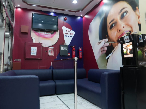 Dental practice waiting room with braces ad on wall