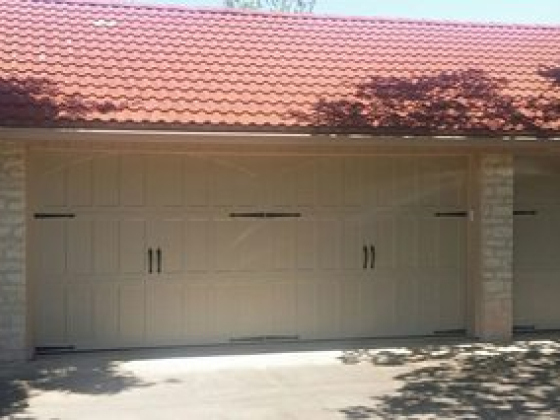 Garage with double doors and red roof tiles in sunlight