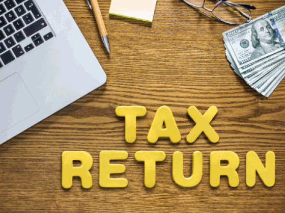 Workspace showing tax return letters and cash.