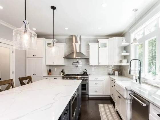 Bright kitchen featuring white cabinetry and elegant lighting.