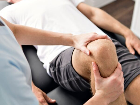 Therapist assesses knee movement of a client.